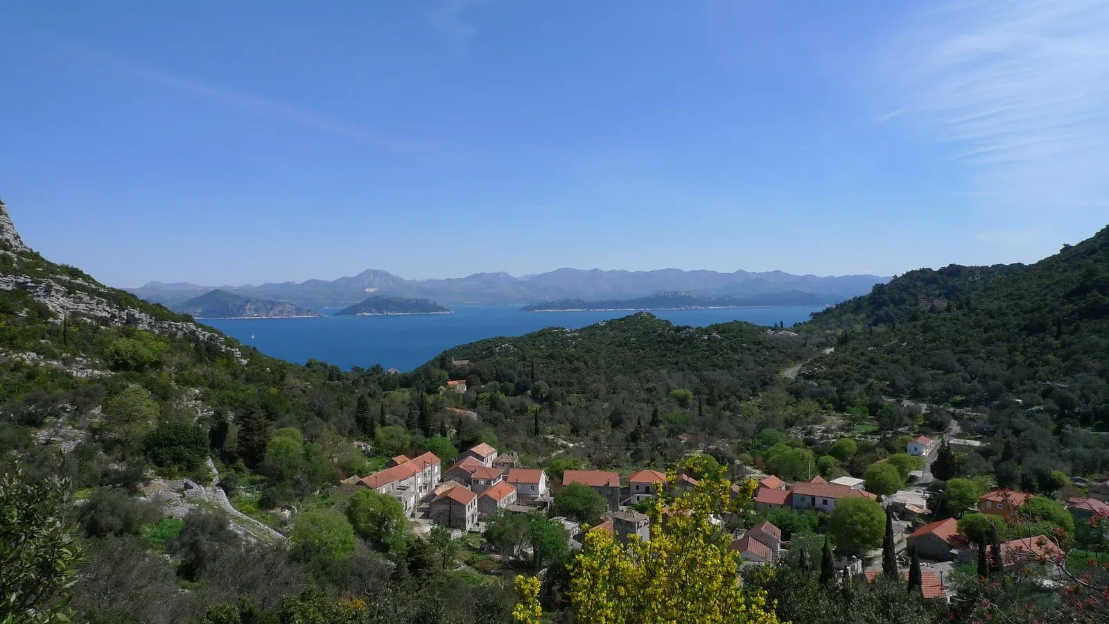 Village among forested hills above a blue bay on Mljet