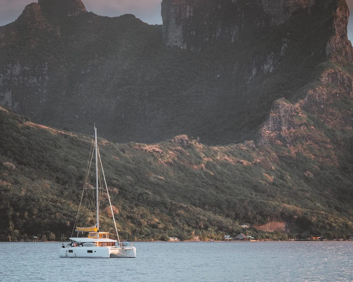 Catamaran anchored below the steep green slopes of Bora Bora