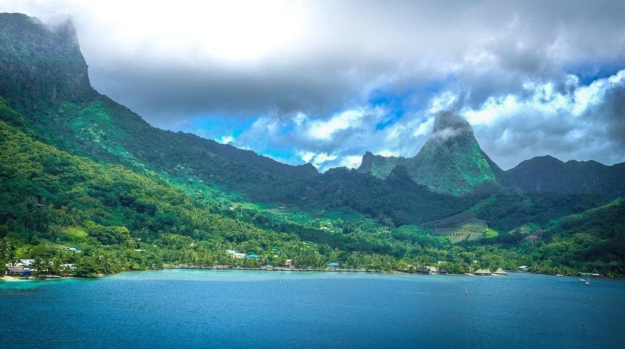 Green peaks of Moorea above a calm bay and shoreline village
